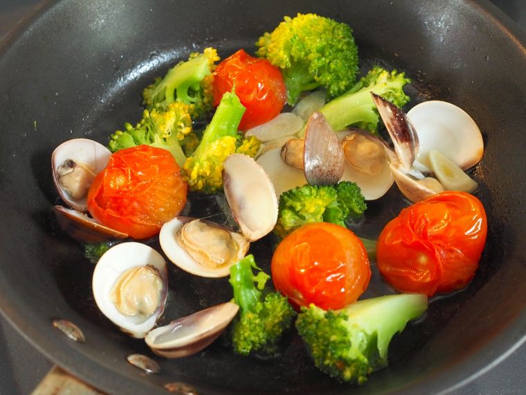 フライパンではまぐりを調理している様子