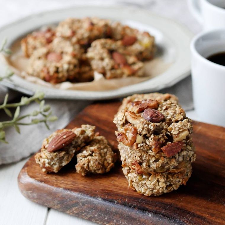 木の皿の上に置かれたバナナとオートミールのクッキー