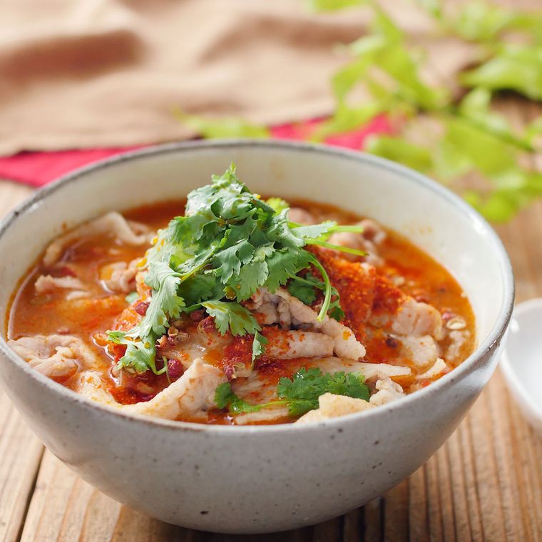グレーの器に盛られた豚バラ肉と小松菜入り四川風スープ