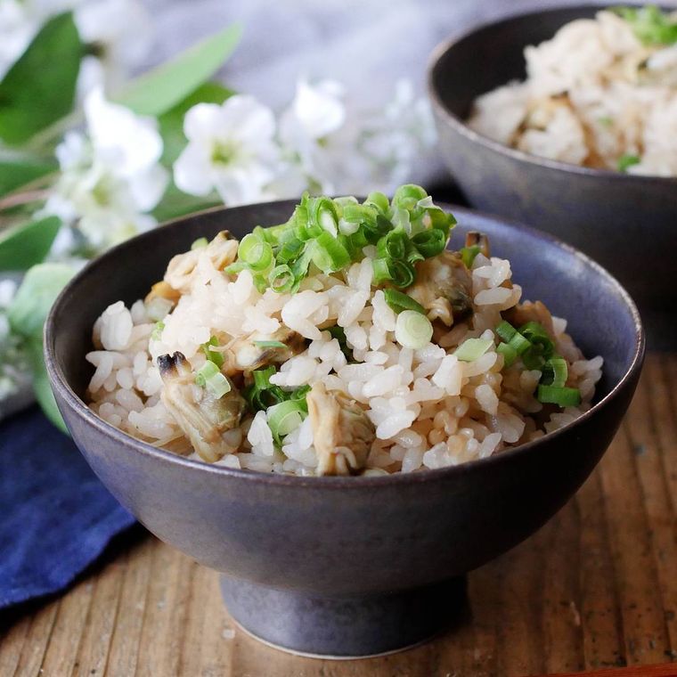 黒い茶碗に入っているしょうが入りあさりご飯