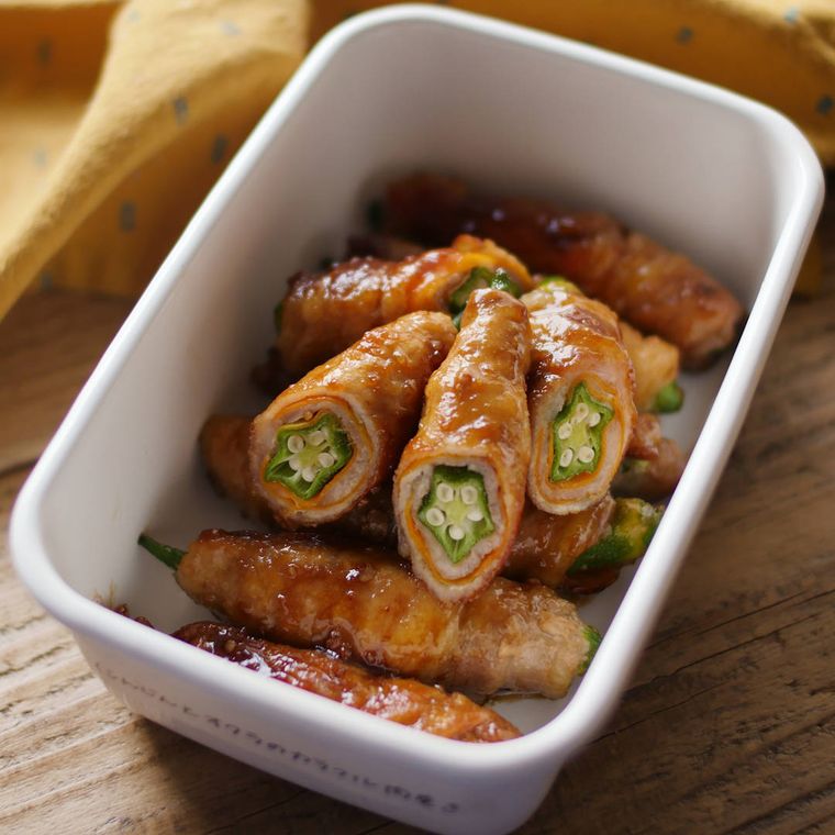 白い四角の保存容器に入ったにんじんとオクラの肉巻き