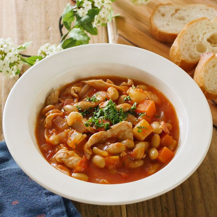 白い皿に盛りつけられたにんじんや玉ねぎ入りのポークビーンズ