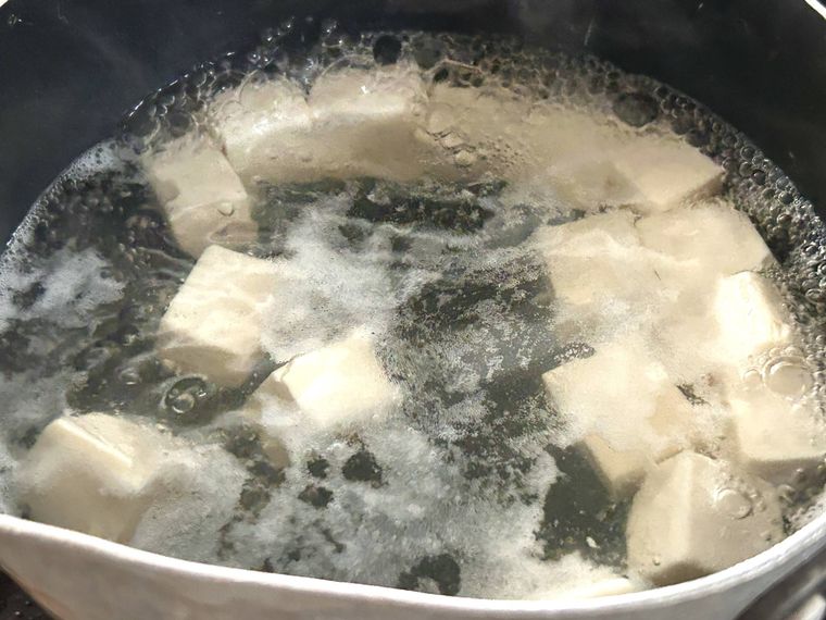カットした絹豆腐を鍋でゆでているところ