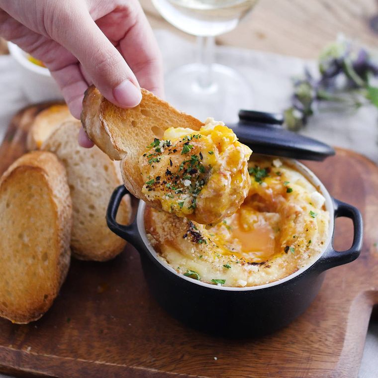 ウッドボードに盛り付けられた半熟卵とコンビーフのチーズホットディップ