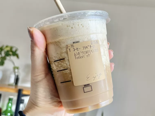 カスタマイズされたコーヒー フラペチーノを手に持っている