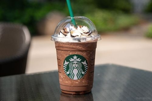 カスタマイズしたバニラ クリーム フラペチーノが黒いテーブルに置かれている様子