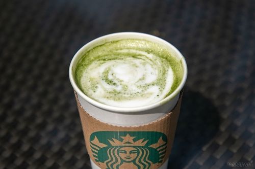 エスプレッソショットを追加した抹茶 ティー ラテが黒いテーブルに置かれている様子