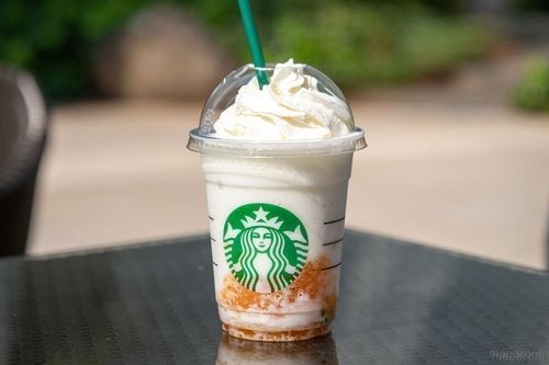 シトラス果肉入りのバニラ クリーム フラペチーノが黒いテーブルに置かれている様子