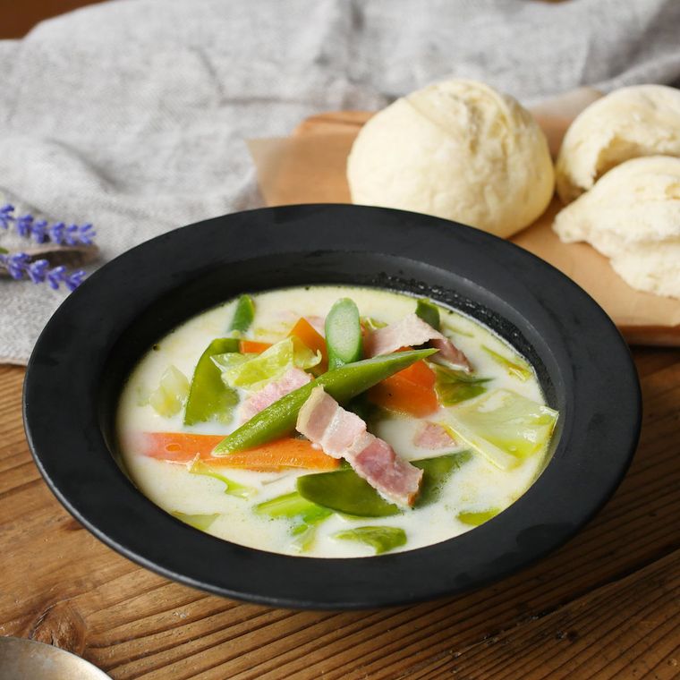 器に盛り付けられたアスパラガスと絹さや、ベーコンのミルクスープ