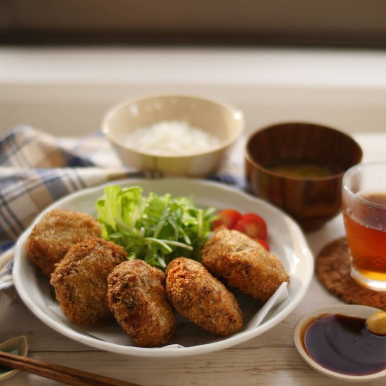 丸皿に盛り付けられた高菜メンチカツと野菜、高菜メンチカツ定食