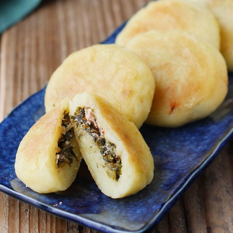 皿に並べられている高菜明太おやき、表面がきつね色に焼けた高菜明太おやき