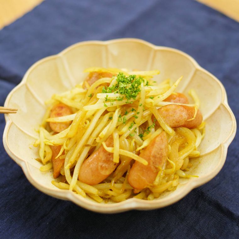 ベージュの皿にのった、もやしとウィンナーのカレー炒め