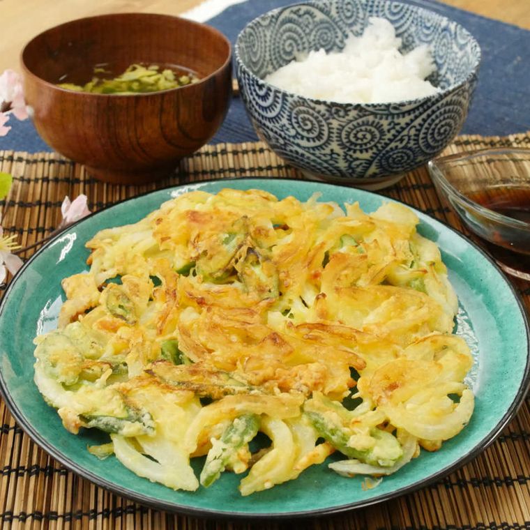 緑色の皿にのった、ビックサイズかき揚げ