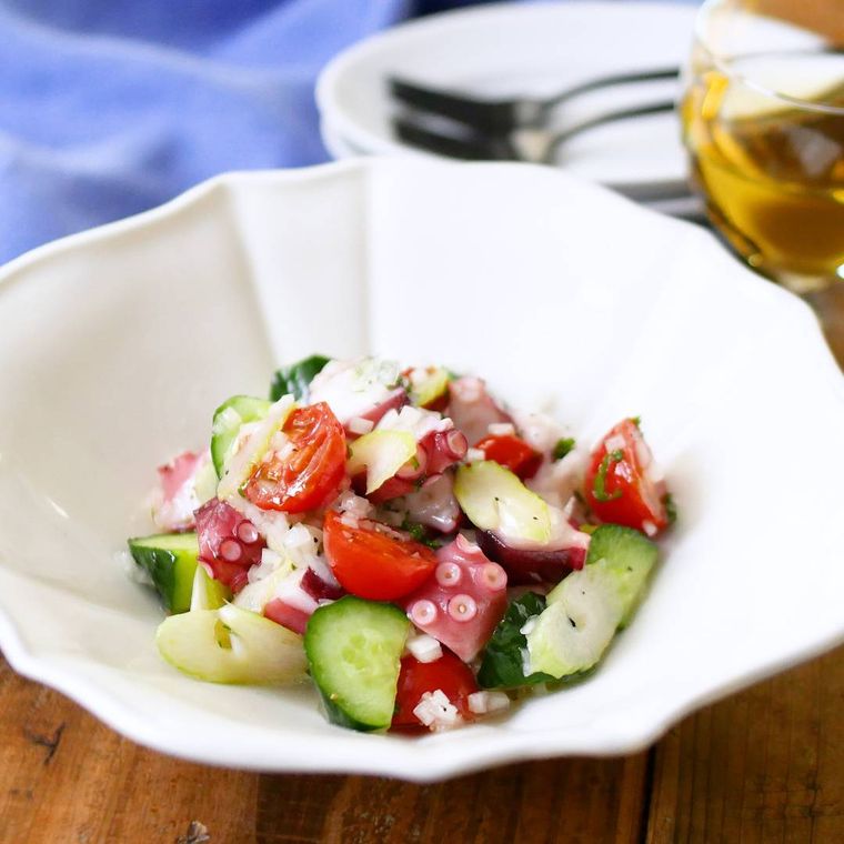 白い深皿に盛りつけられたゆでだことミニトマトのマリネサラダ