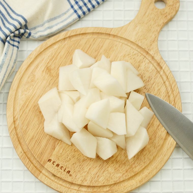 カッティングボードの上の包丁と、乱切りされた大根