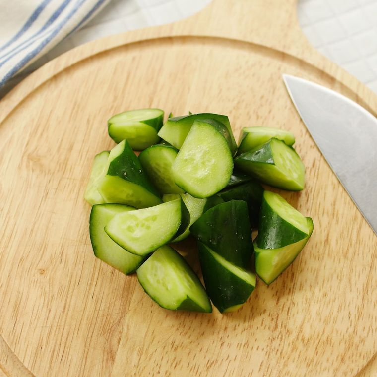 カッティングボードの上の包丁と、乱切りされたきゅうり