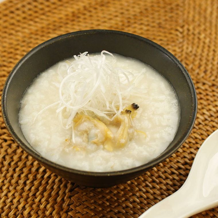 黒い丼に盛られたあさりの中華粥