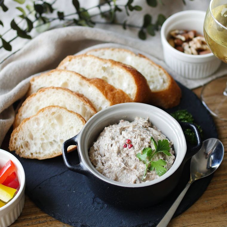 持ち手付きの器に入れてスライスしたバゲットを添えた、さば缶とクリームチーズのパテ