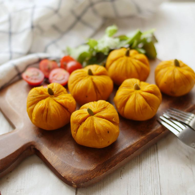 手付きの木製ボードに付け合わせと盛られた、かぼちゃのサラダ茶巾絞り