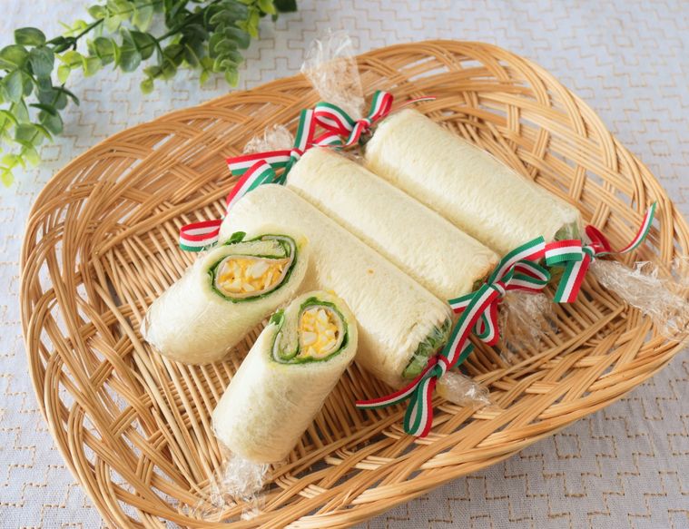 かごのトレーに並べたロールサンドイッチ