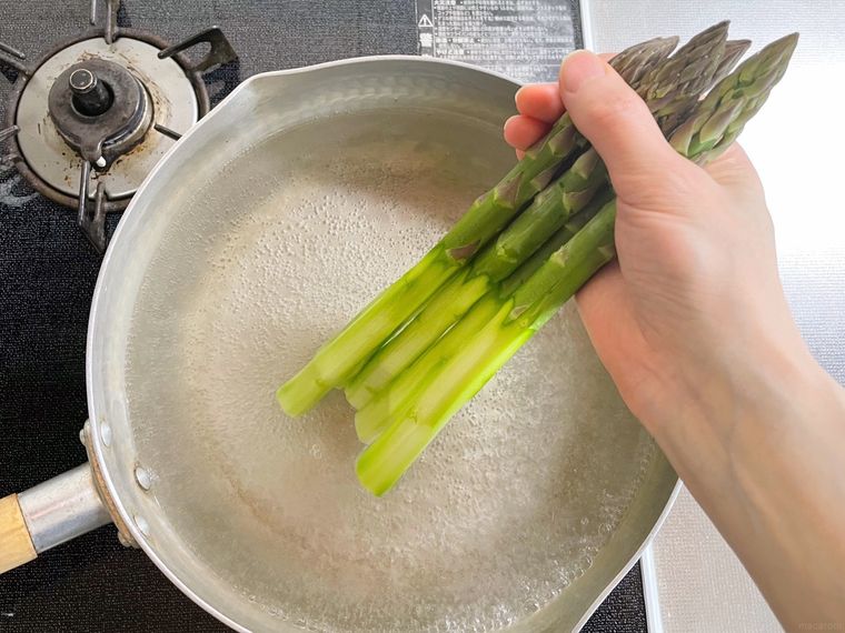 沸騰した鍋にアスパラガスの根元部分を入れている様子
