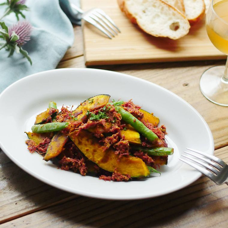 楕円形の白い皿に盛り付けたコンビーフのスパイシー炒めにフォークが添えてある様子