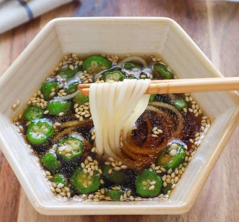 オクラが入ったつゆにそうめんをつけている様子