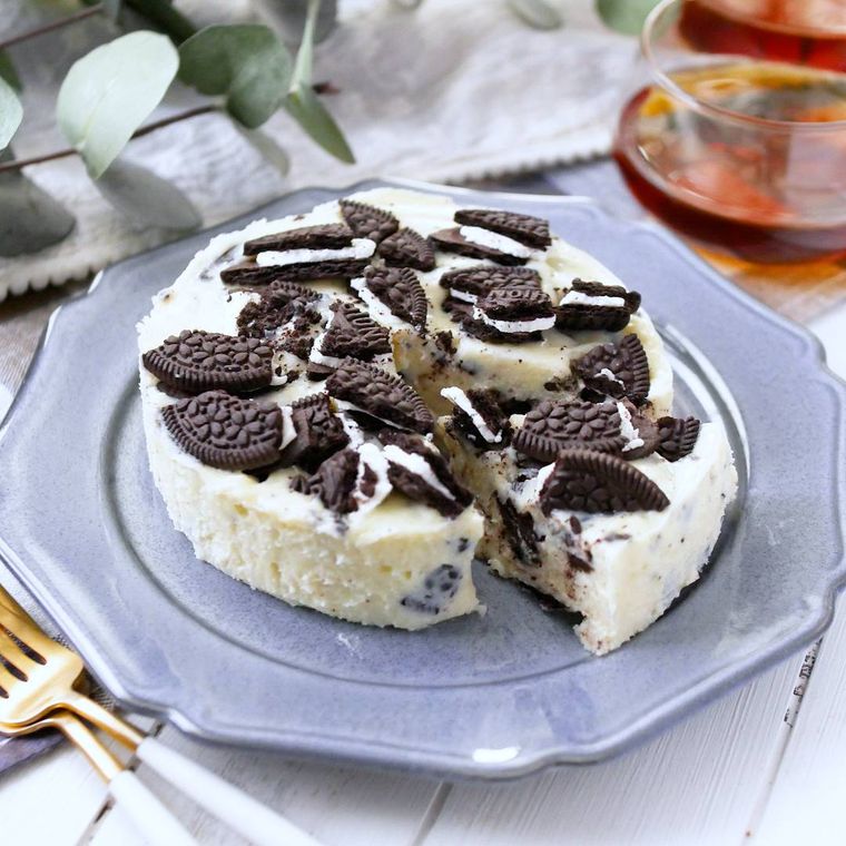 白いケーキに黒いオレオクッキーをザクザクとのせてひと切れカットしている
