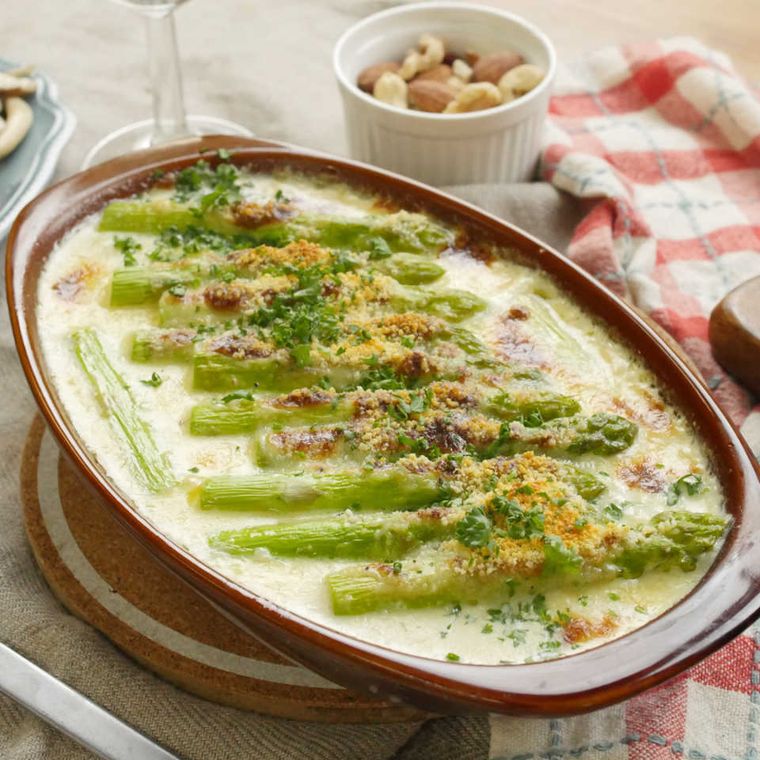 茶色のグラタン皿に入っているアスパラガスのチーズチャウダー