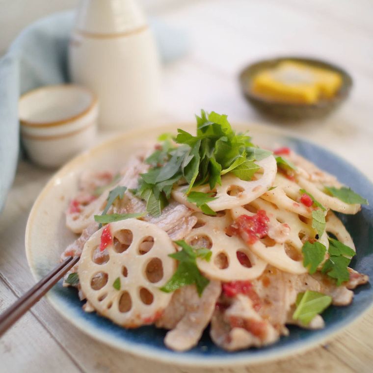 白と青の皿に盛りつけられた豚肉とれんこんのさっぱり梅みりん和え