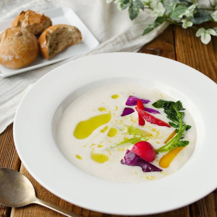 白い皿に盛りつけられたいろんな野菜入りのバーニャカウダ風スープ