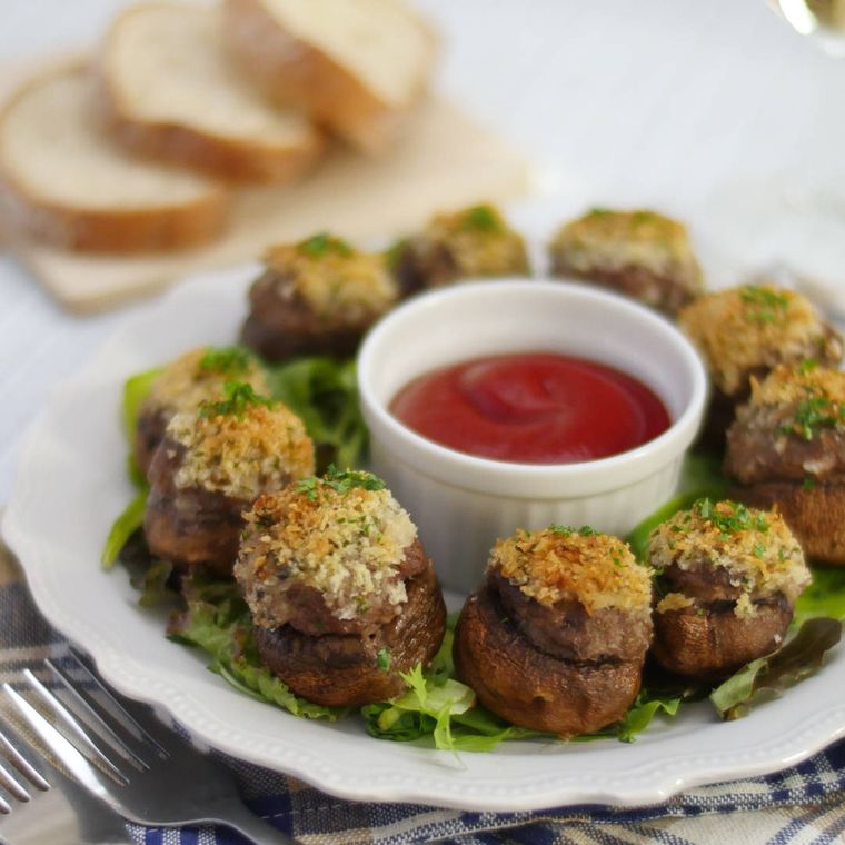 皿に盛りつけられた肉詰めマッシュルームのパン粉焼きにケチャップが添えられている