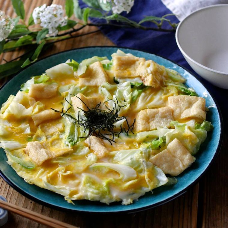 青い皿に キャベツと油揚げの卵とじが盛りつけられている