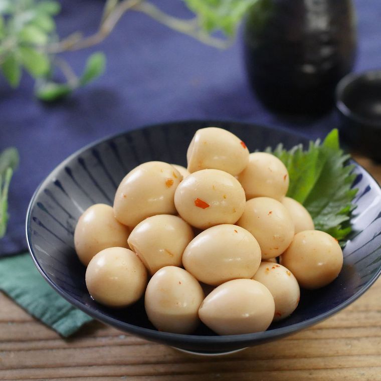 黒い皿に盛られたうずら卵のピリ辛豆板醤漬け