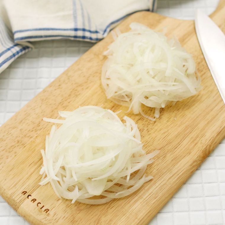 カッティングボードの上で薄切りされた玉ねぎ