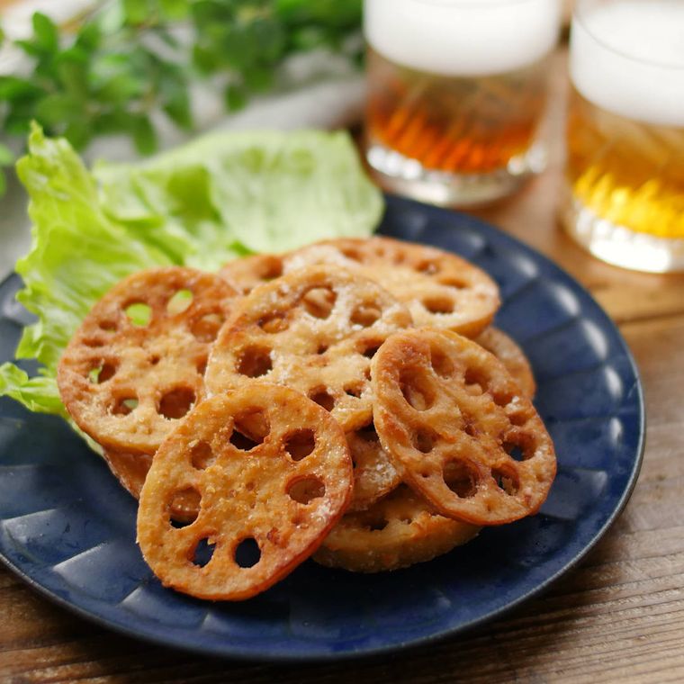 濃色の皿に盛りつけられたれんこんの唐揚げとつけ合わせ