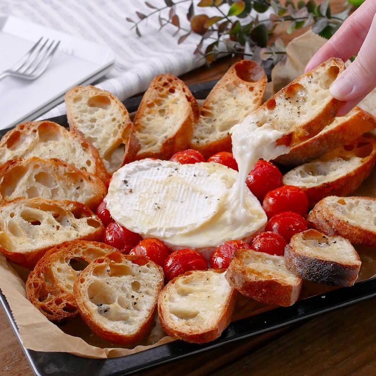 黒い鉄板に盛りつけられたカマンベールチーズフォンデュ