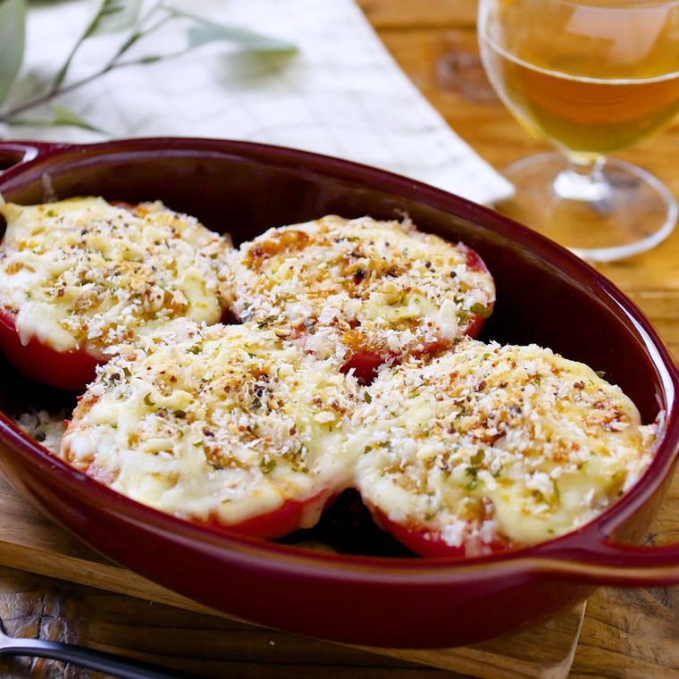 茶色のグラタン皿に盛りつけられたトマトのチーズパン粉焼き