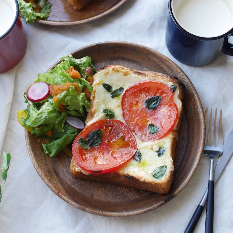 木の丸い皿に盛りつけられた濃厚チーズトースト