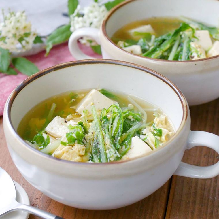 ブラウンに縁どられたスープカップに入っている水菜の中華卵スープ