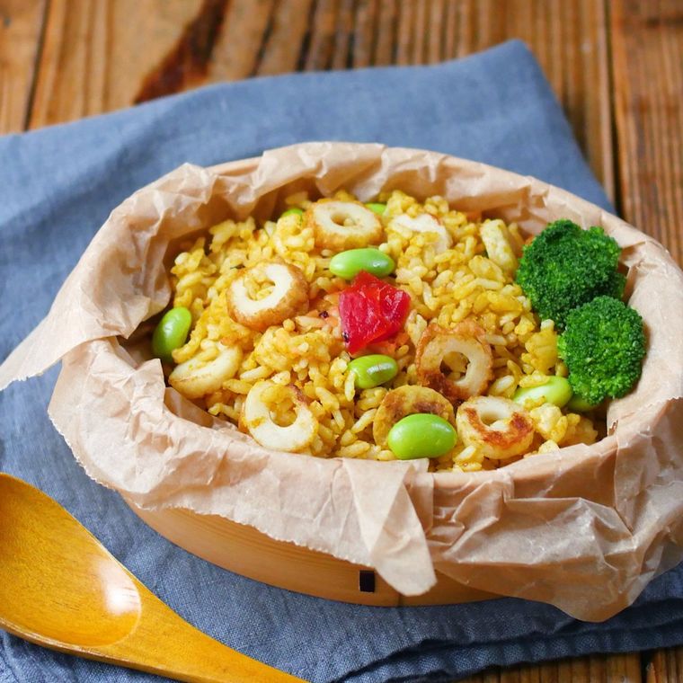 曲げわっぱの弁当箱に入っているちくわと枝豆のカレーチャーハン