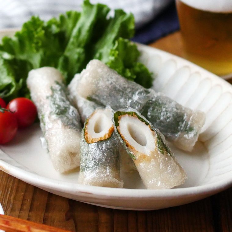 白い長皿に盛りつけられたちくわの揚げ春巻きとつけ合わせの野菜