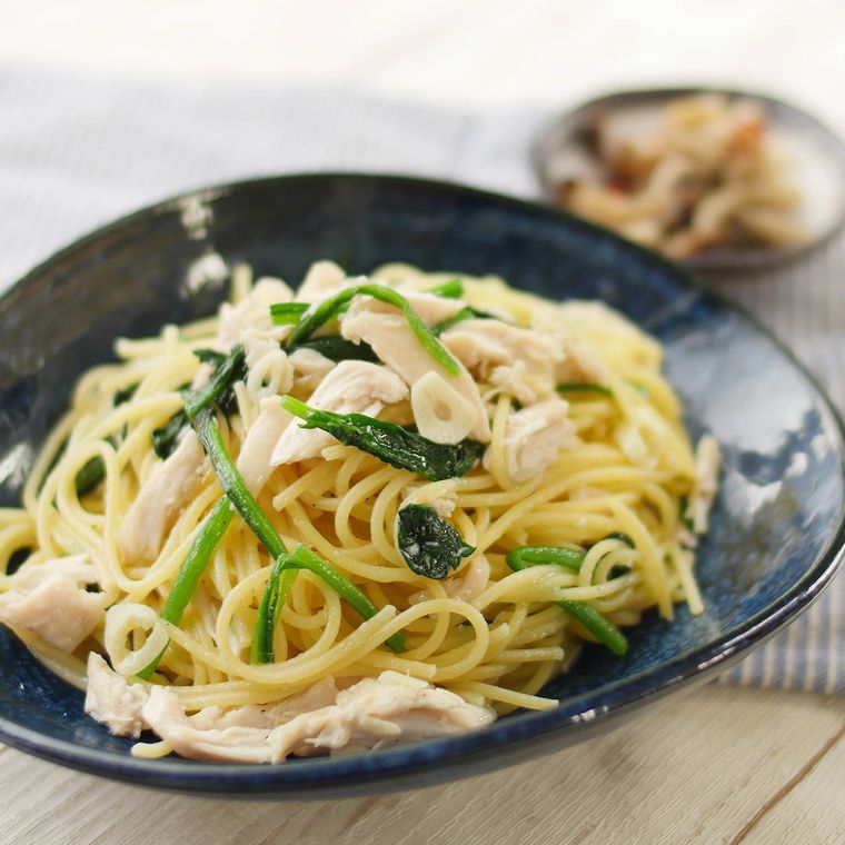 濃紺の皿に盛られた、鶏ささみとほうれん草のオイルソースパスタ