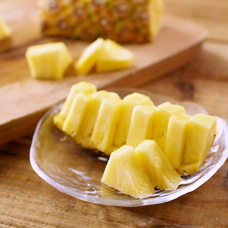 まな板でパイナップルをカットしガラス皿に取り分けた様子