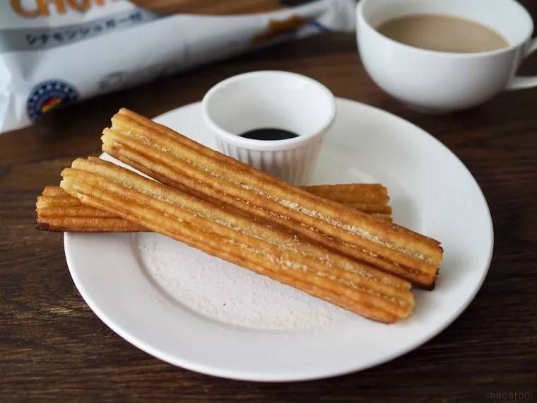 皿に盛り付けたマヘソ チュロスシナモンシュガー付き