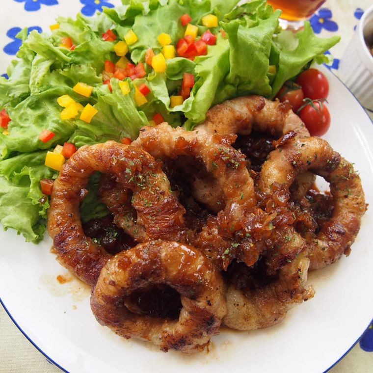 ほかの野菜と一緒に白いプレートの上に盛り付けられたぐるぐる肉巻き玉ねぎのトンデリング