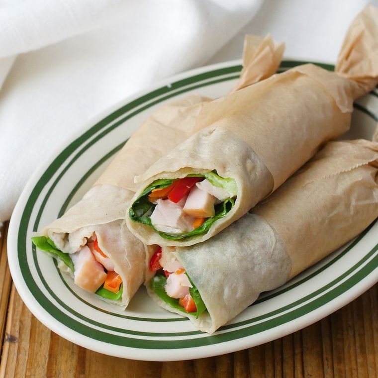 白地に緑色のラインが入った皿に盛られた米粉のラップサンド