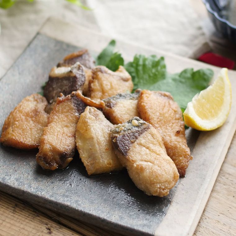 黒い四角い皿に盛りつけられたぶりの柚子胡椒唐揚げ