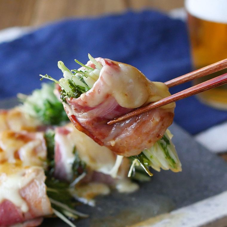 箸でつまみ上げた水菜のベーコンチーズ巻き