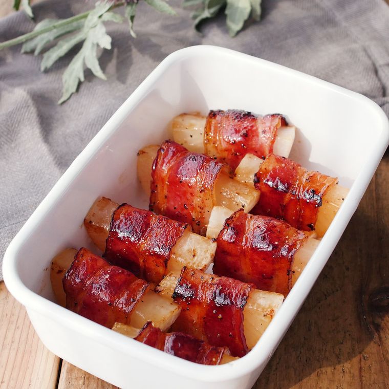 白く四角い容器に並べた大根のベーコン巻きステーキ